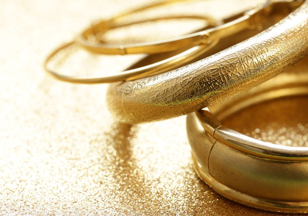 An image of gold bonded jewelry set on a golded surface. 